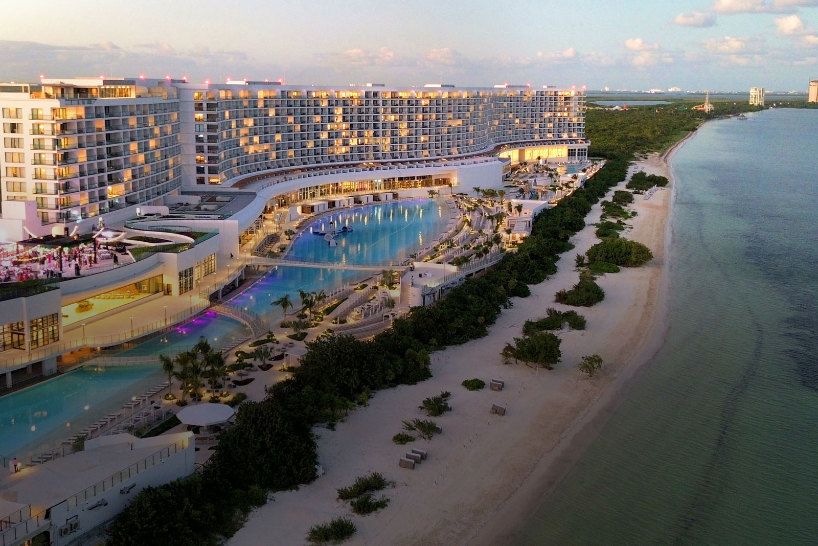 a large hotel with a pool and a beach
